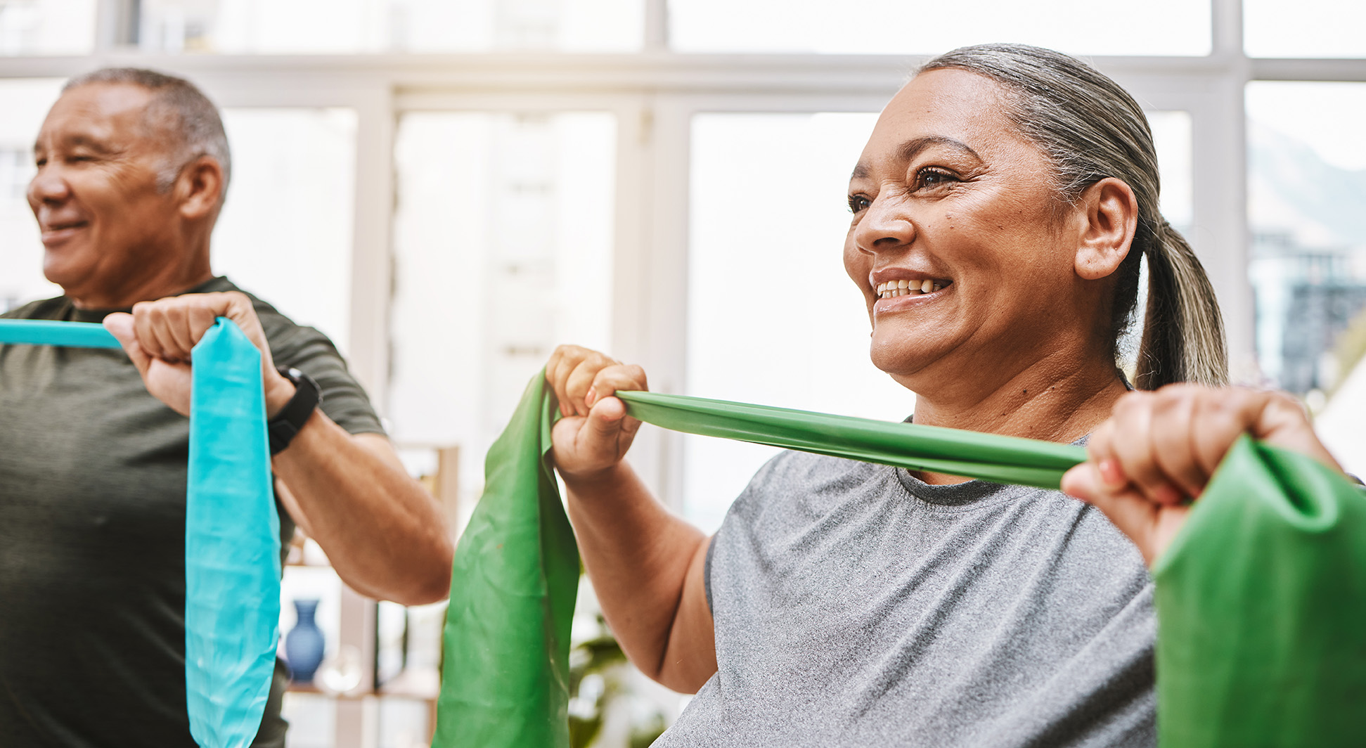 Elderly people exercising smiling as the enjoy a senior exercise class